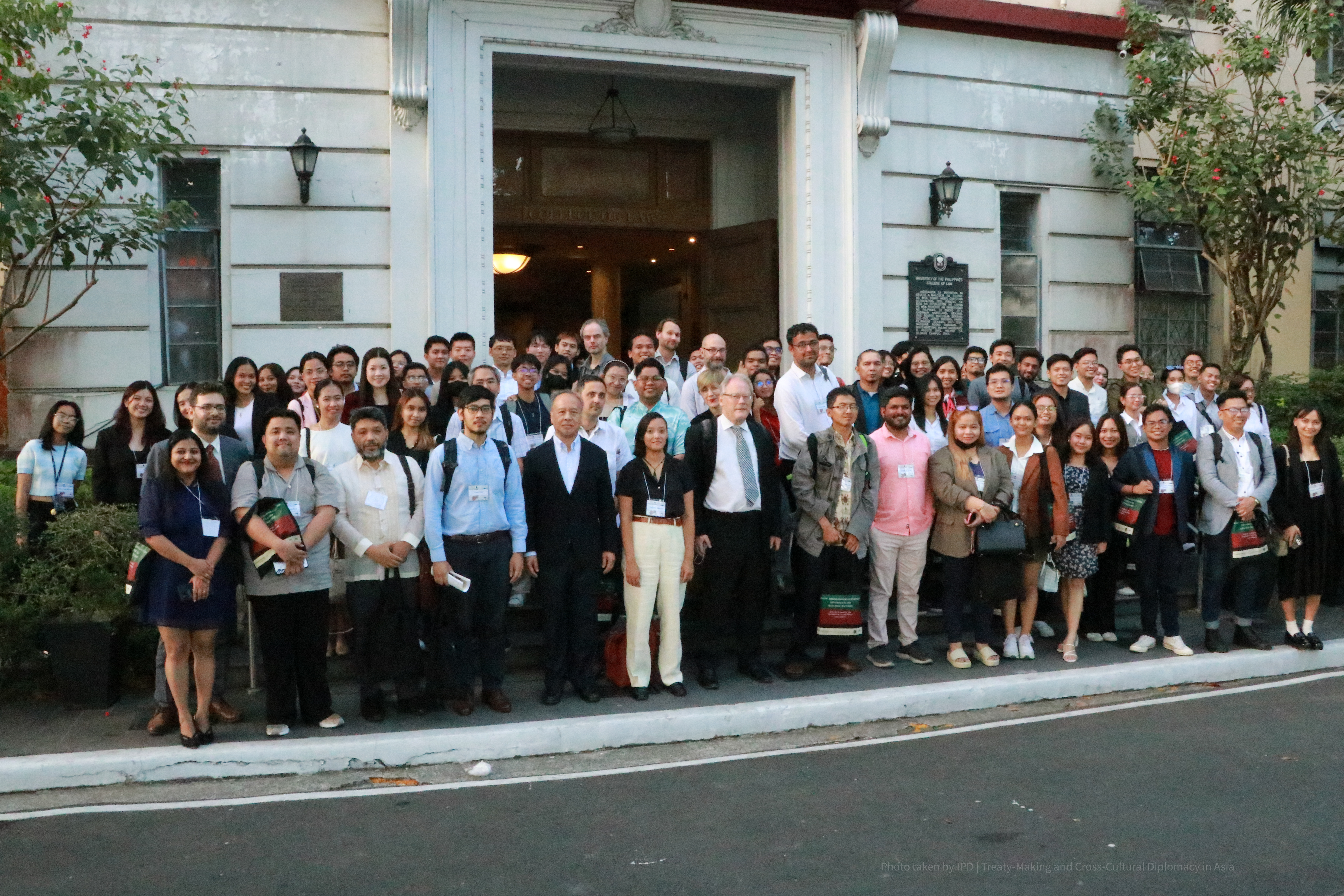 Conference participants standing in a group by the entrance to a building.